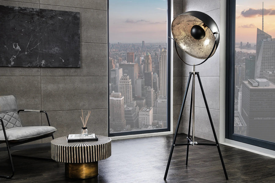 Háromlábú, ezüstszínű design állólámpa.