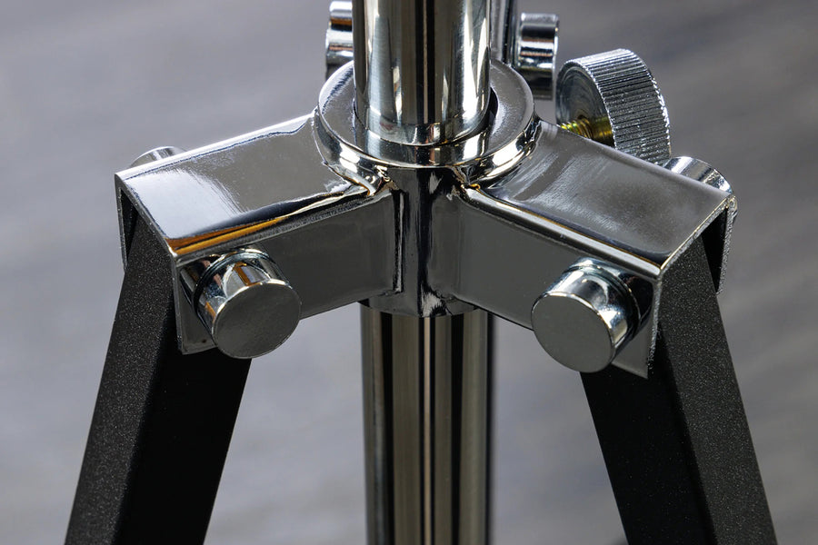 Háromlábú, ezüstszínű design állólámpa.