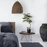 Zöld színű, mű cédrus bonsai fa, fekete színű műanyag cserépben.