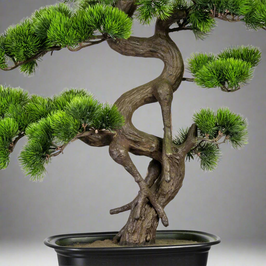 Zöld színű, mű fenyő bonsai fa, fekete színű, ovális műanyag cserépben.