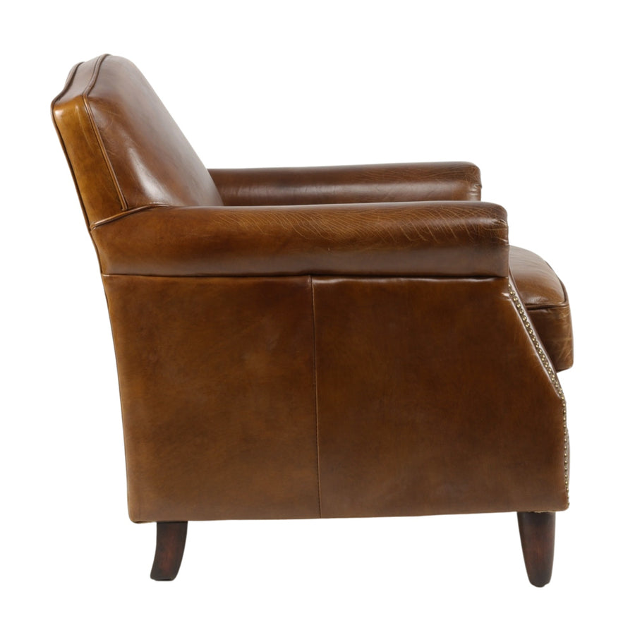 A Normandie vintage fotel bal oldali nézete, jól látható a természetes bőr textúrája és az ívelt karfa formája.