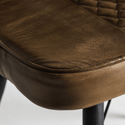 Karamell bőrkárpit természetes textúrája a Brouse szék ülőfelületén.