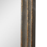 Közelkép a falitükör arany patinázott fakeretének részletéről.