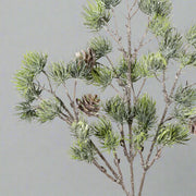 Jeges, glitteres felületű, tobozokkal díszített mű cédrusfenyő ág.