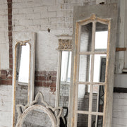 Rusztikus térben elhelyezett vintage falitükör több antik tükörrel együtt.