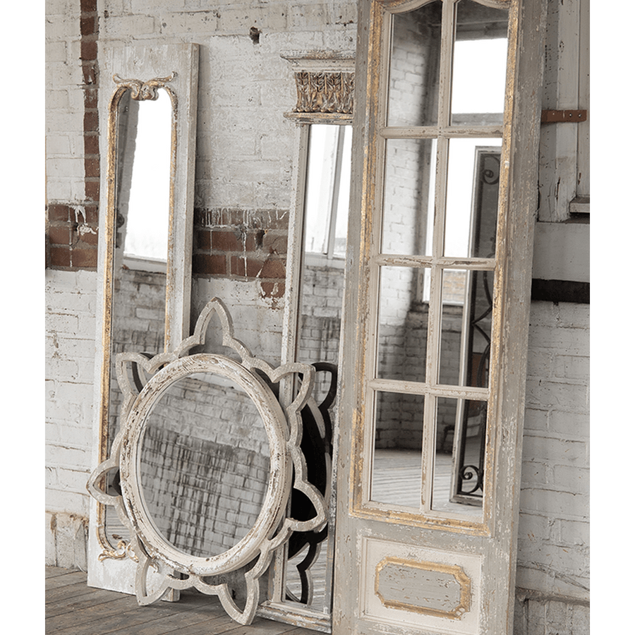 Rusztikus térben elhelyezett vintage falitükör több antik tükörrel együtt.