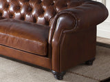Chesterfield stílusú, háromszemélyes konyakbarna bőrkanapé.