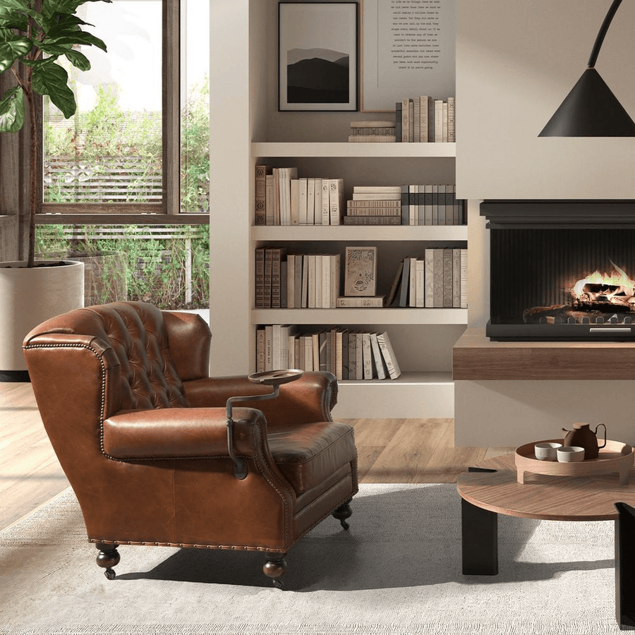 Chester konyakbarna bőrfotel könyvespolc mellett, kandallóval a háttérben