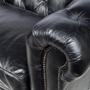 Közelkép a Chesterfield kanapé karfájáról, a gombszegecsekkel és a finom textúrájú bőrrel.