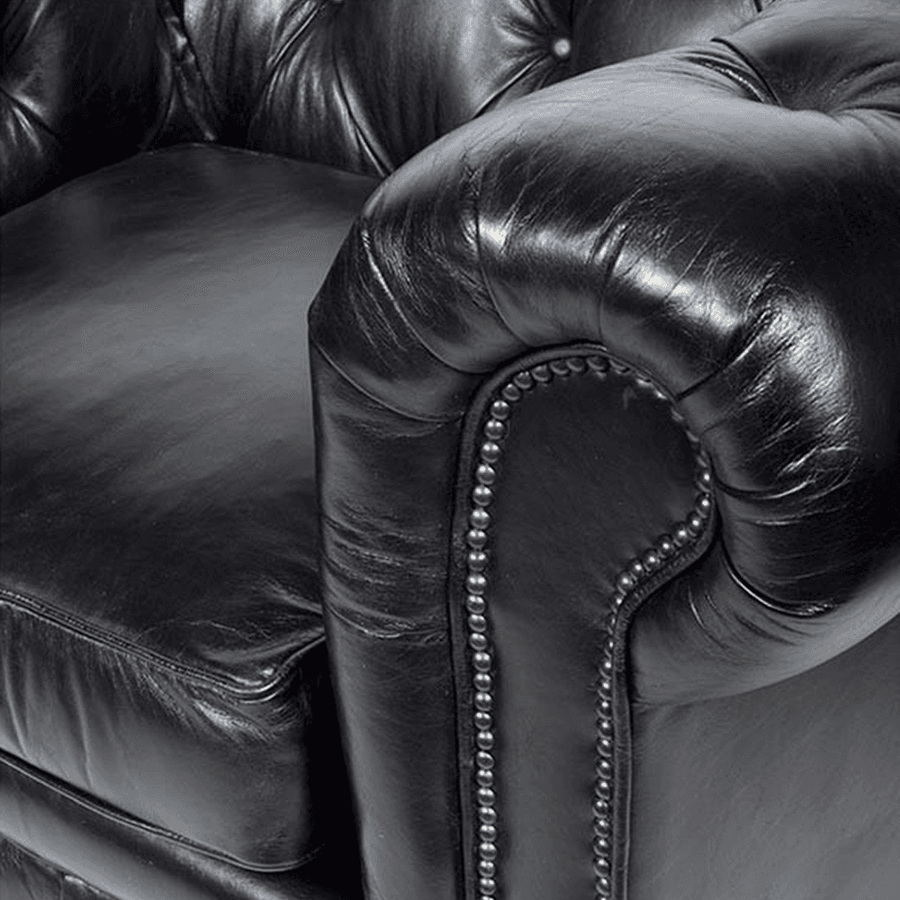 Közeli kép a fotel karfájáról és a szegecselt szegélyezés részleteiről.