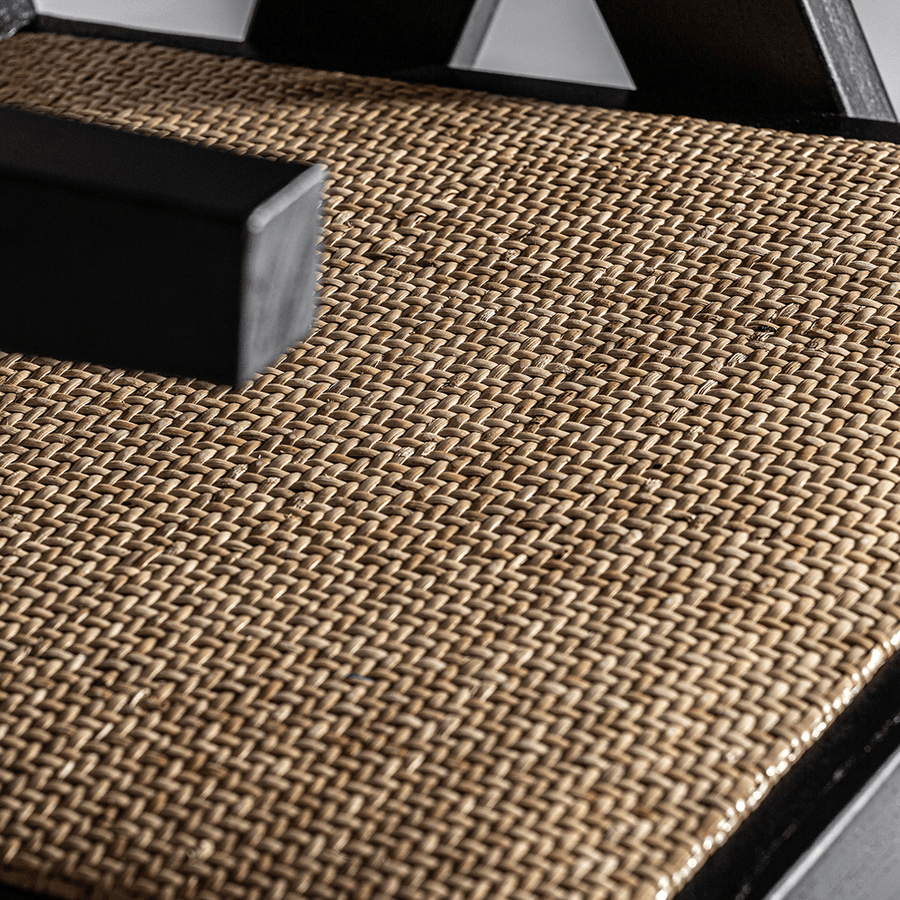 Rattan ülőfelület közelről, fekete fakeretben.