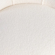 Háttámla varrásainak közeli képe a textúrált bouclé felületen.