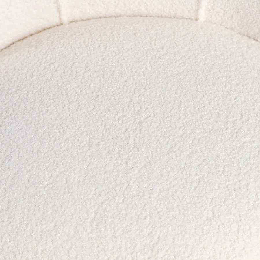 Háttámla varrásainak közeli képe a textúrált bouclé felületen.