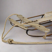 Natúr színű dekor szánkó kormányrészének részletfotója kötéllel és szegecsekkel.