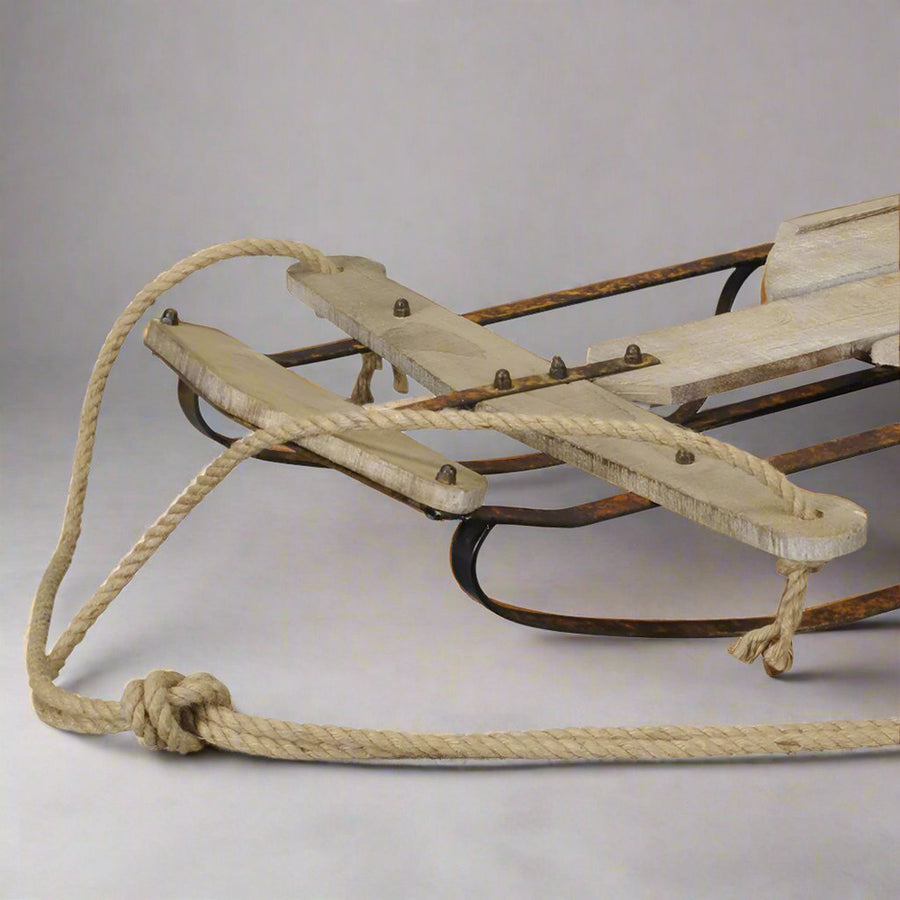 Natúr színű dekor szánkó kormányrészének részletfotója kötéllel és szegecsekkel.