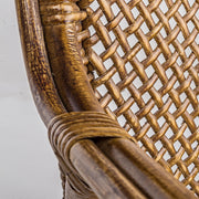 Közeli részlet az EDELINA mézbarna rattan szék fonott háttámlájáról és karfájáról.