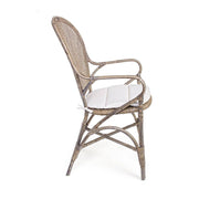 Oldalnézetből látható EDELINA natúr rattan szék karfával és fehér ülőpárnával