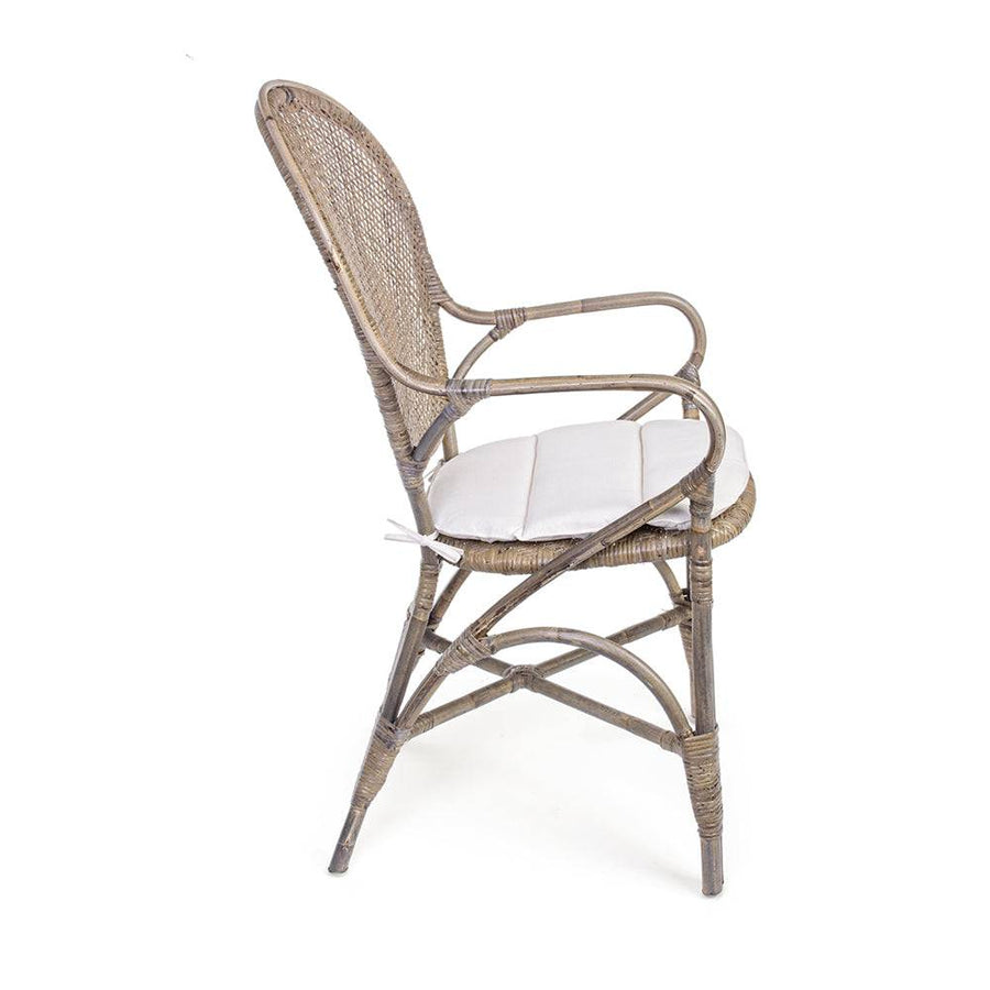 Oldalnézetből látható EDELINA natúr rattan szék karfával és fehér ülőpárnával