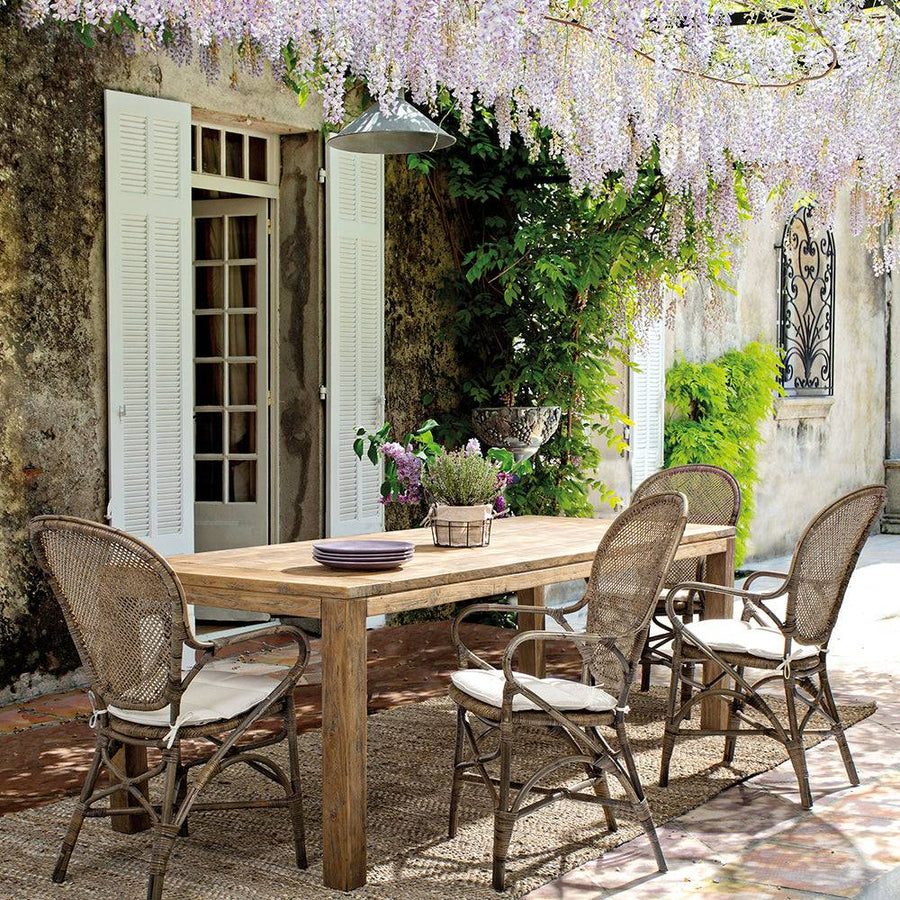 Kültéri elrendezésben használt EDELINA székek natúr rattanból, fa étkezőasztal mellett