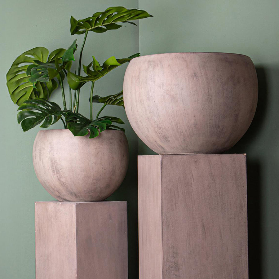 Közelkép az antik hatású homokszínű kaspó szettről növényekkel, zöld fal előtt