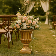 Dekoratív arany kaspó virágkompozícióval kültéri esküvői helyszínen