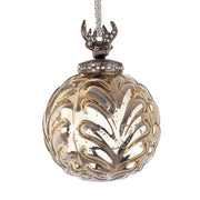 Gömb formájú, fém szarvas fejjel díszített, ezüstszínű, enyhe arany patinával rendelkező, dombormintás üvegből készült dekoratív karácsonyfadísz.