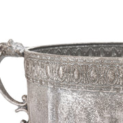 Ezüstszínű, dombormintával díszített, lábakon álló fém kaspótál.