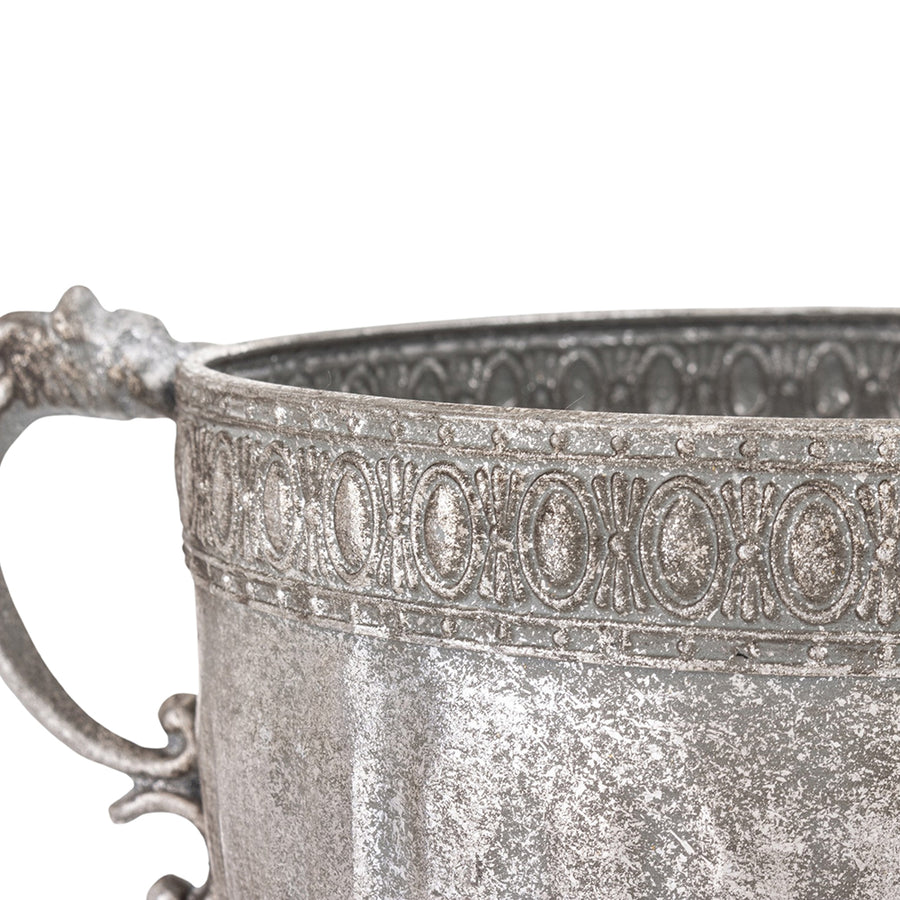 Ezüstszínű, dombormintával díszített, lábakon álló fém kaspótál.