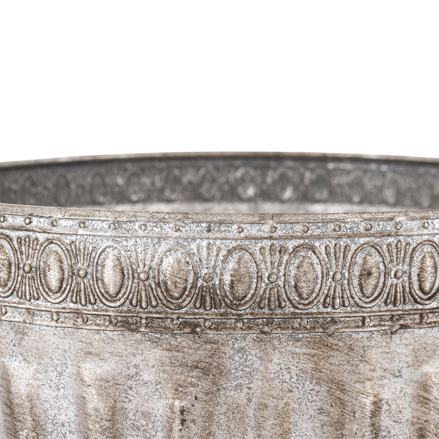 Ezüstszínű, dombormintával díszített, lábakon álló fém kaspó tál.
