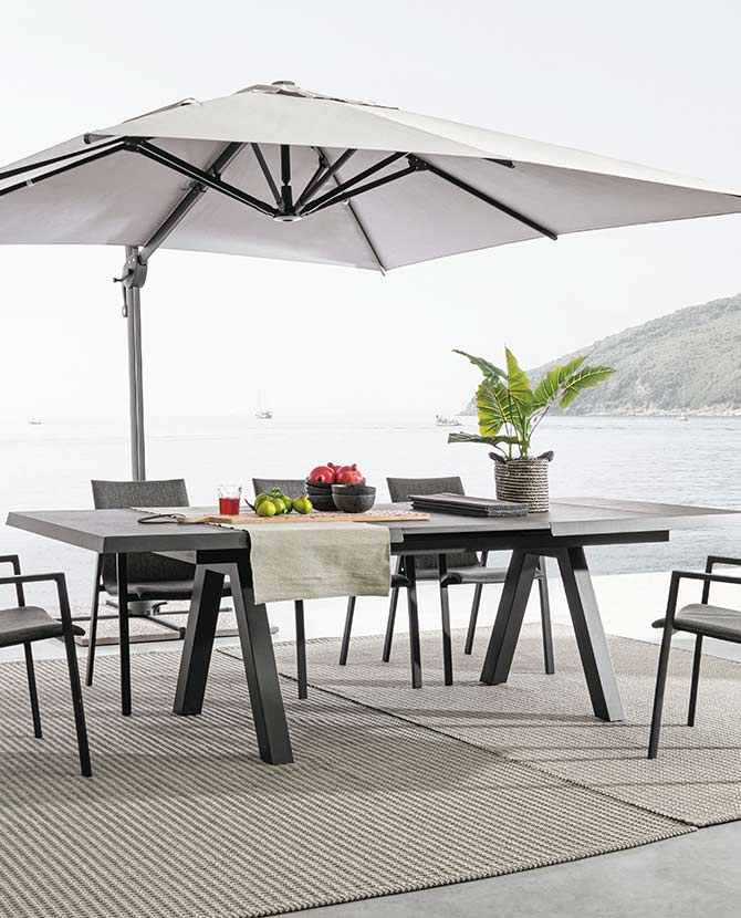 Fekete színű modern kerti asztal napernyővel és székekkel.