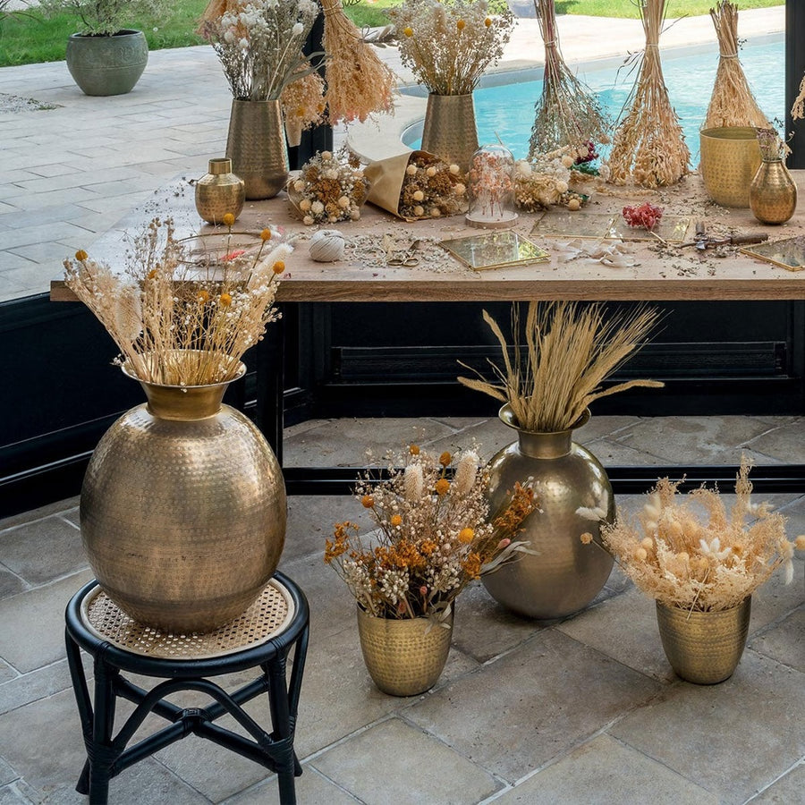 Antikolt felületű,, rézszínű, kalapált fémből készült kézműves váza, száraz virágokkal.