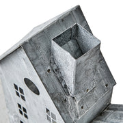 Szürke színű, bádogból készült házikókat formázó lámpás.