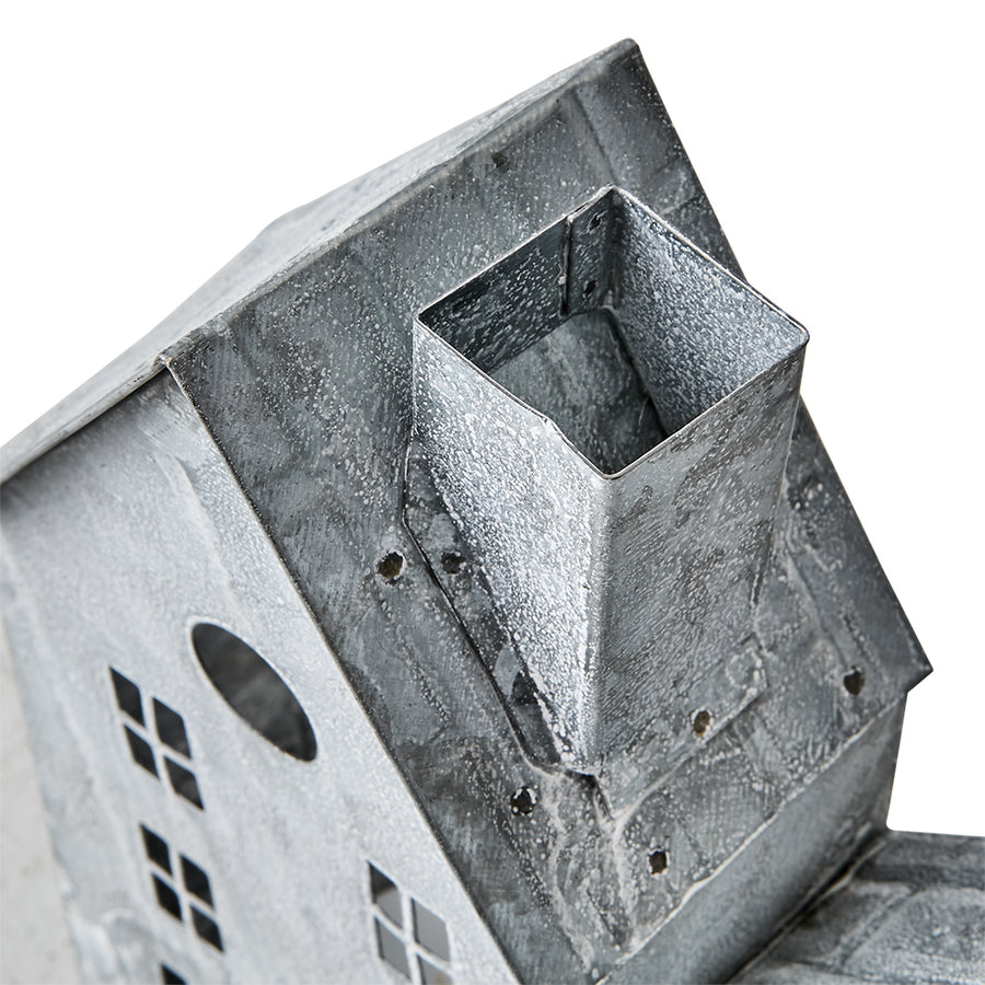 Szürke színű, bádogból készült házikókat formázó lámpás.