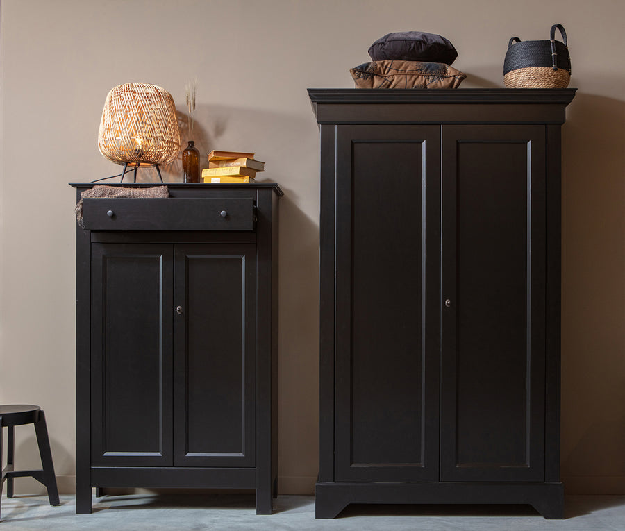 Matt fekete színű, 1 fiókkal és 2 polccal rendelkező, zárható kialakítású, kétszárnyas fenyőfa komód.