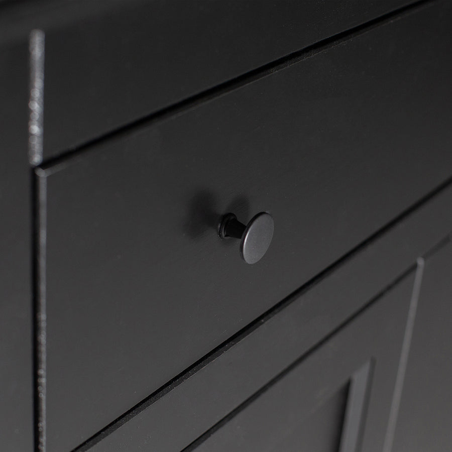 Matt fekete színű, 1 fiókkal és 2 polccal rendelkező, zárható kialakítású, kétszárnyas fenyőfa komód.