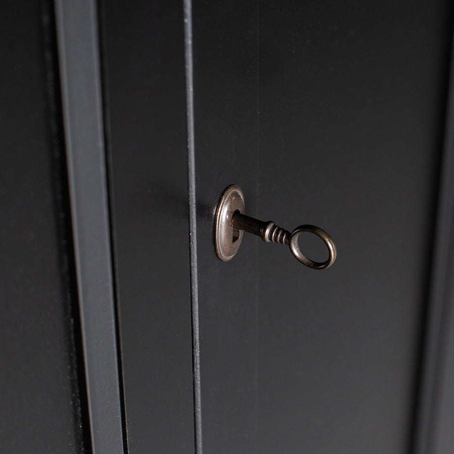 Matt fekete színű, 1 fiókkal és 2 polccal rendelkező, zárható kialakítású, kétszárnyas fenyőfa komód.