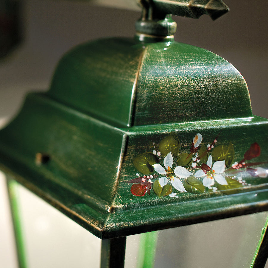 Közelkép a Ferroluce Gorizia lámpa kézzel festett virágmintás díszítéséről a zöld színű fém burán.