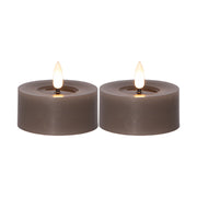 Két darab szürkésbarna színű, valódi viaszból készült LED teamécses meleg fényű, égő lángot utánzó hatással, fehér háttéren.