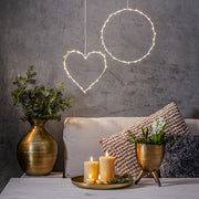 Bézs Flow LED gyertyák tálcán elhelyezve egy modern nappaliban, dekorációs világítással és száraz növényes vázával – meleg, meghitt otthoni hangulat