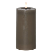 Szürkésbarna, henger alakú LED gyertya meleg fehér lánggal, fehér háttér előtt, 17,5 cm magas kivitelben.