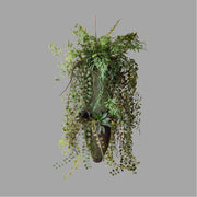 Különböző fajtájú, zöld műnövényekből készült, függeszthető dekoráció.