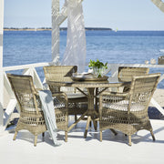 Üveglappal fedett, antikszürke színű, műrattan kerti asztal.