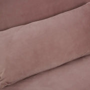 Púderpinkszínű bársonnyal kárpitozott, dönthető háttámlájú, ággyá alakítható 3 személyes kanapé.