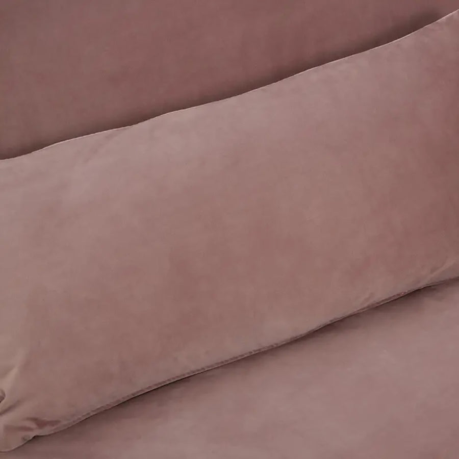 Púderpinkszínű bársonnyal kárpitozott, dönthető háttámlájú, ággyá alakítható 3 személyes kanapé.