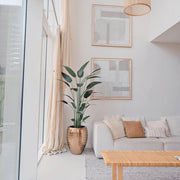 Modern nappaliban elhelyezett Heliconia mű rákollóvirág dekoratív kaspóban, világos enteriőrben