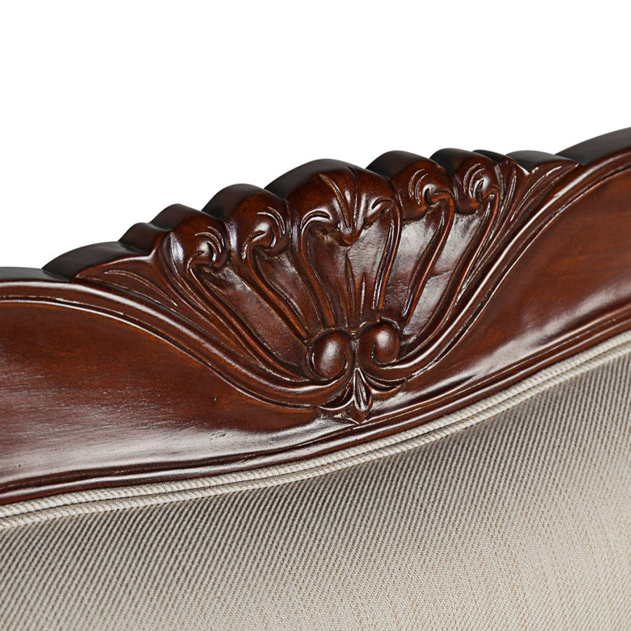 Részletfotó a kanapé háttámlájának kézzel faragott díszítéséről.