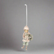 Heritage pink téli kisfiú karácsonyfadísz 11 cm, vintage stílusban, ajándékot és koszorút tartva.