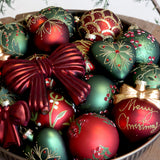 Havas hatású bogyókkal díszített Heritage zöld üveggömbök arany mintás díszek és szívdísz társaságában.