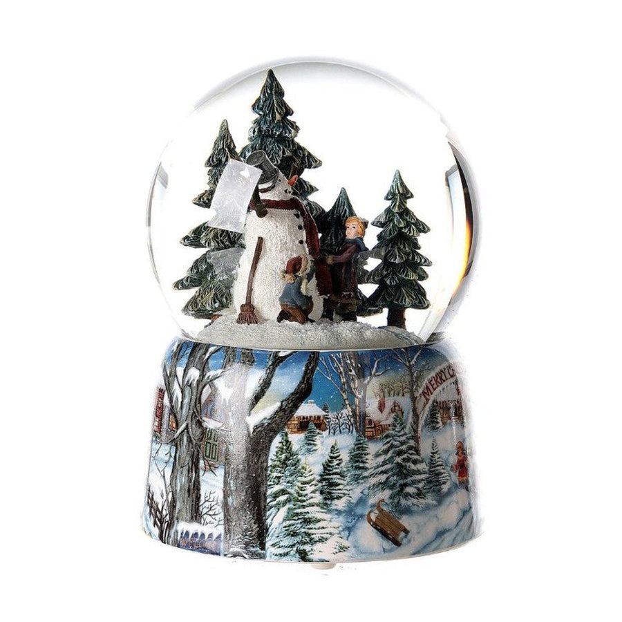 Karácsonyi zenélő-forgó hógömb, téli havas erdőben hóembert építő gyerekekkel.