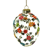 Plasztikus virágokkal díszített, függeszthető húsvéti üvegtojás.